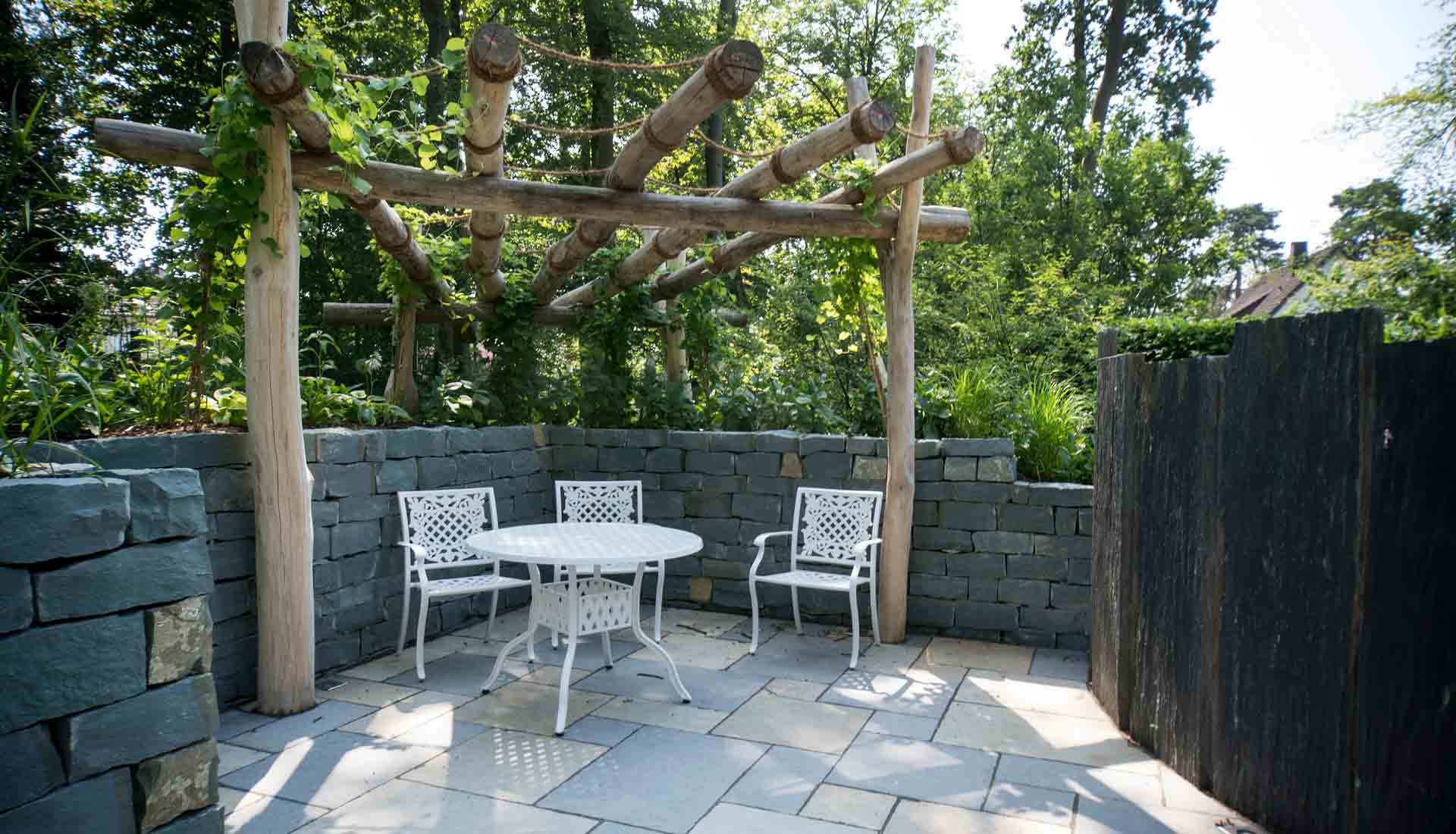 Terrasse mit Steinboden und Natursteinmauer