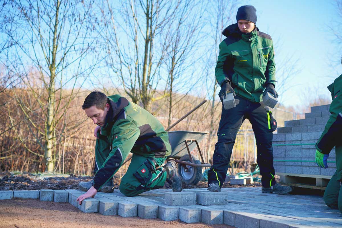 Verlegen von Pflastersteinen für Gartenterrasse